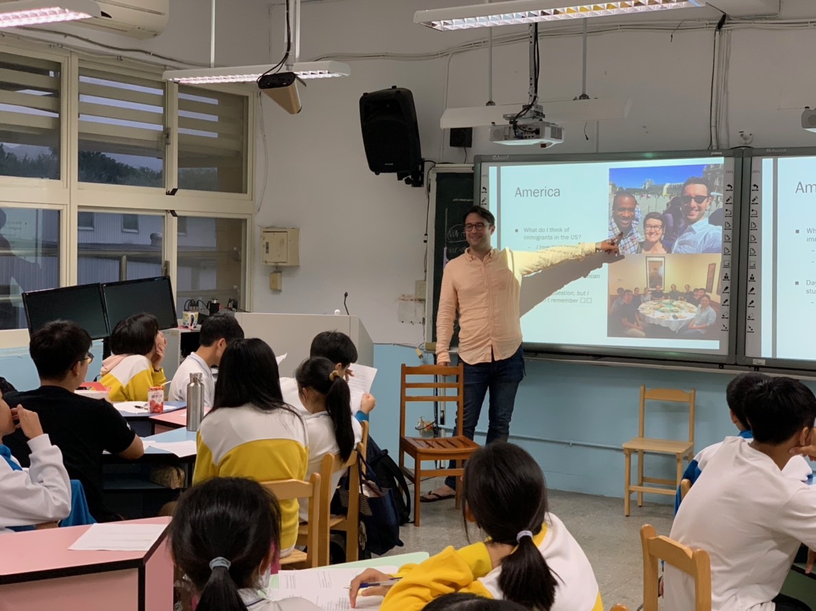 Photo of Adam presenting his slides in the middle school classroom. 